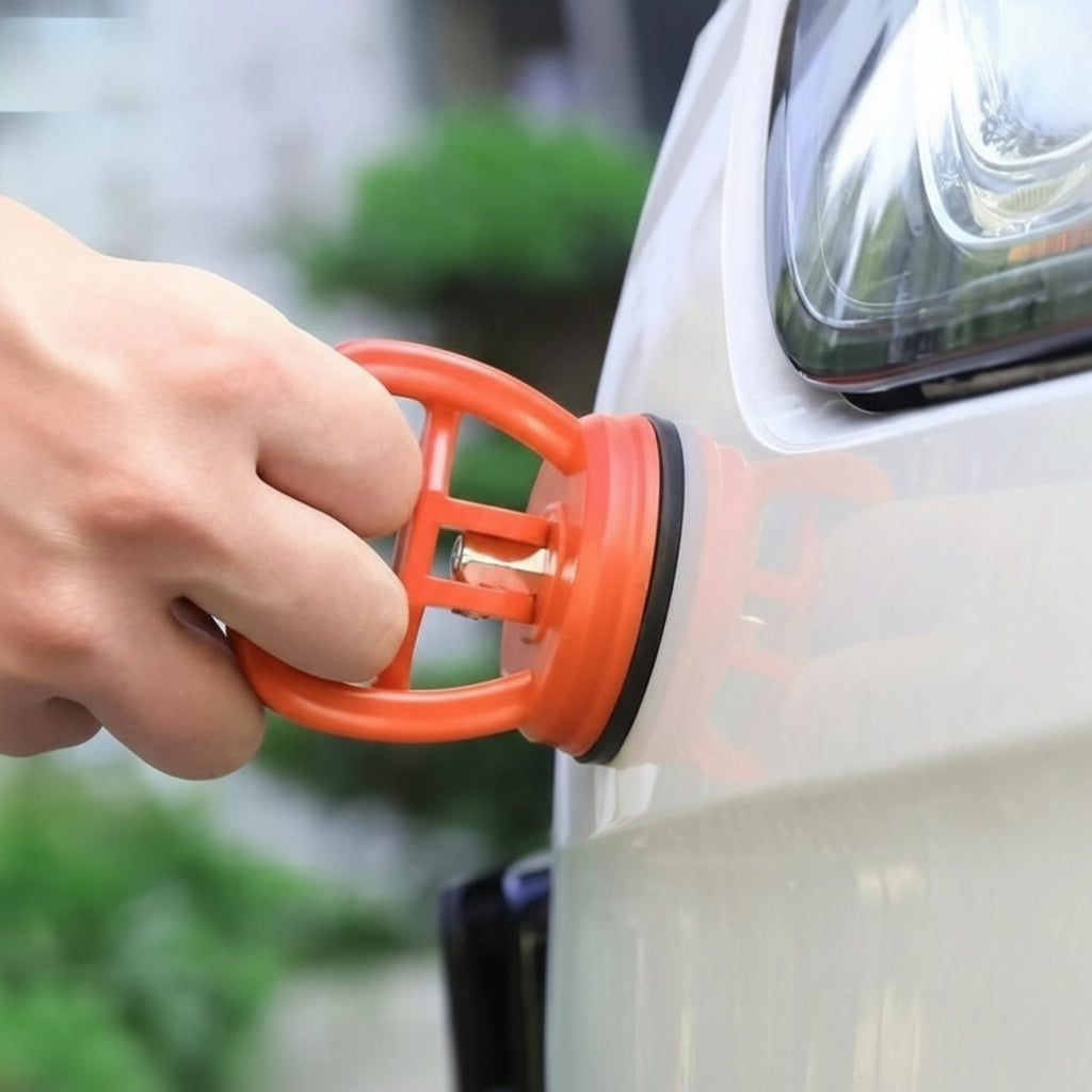 Hand using an orange car air freshener clip on a car's air vent.