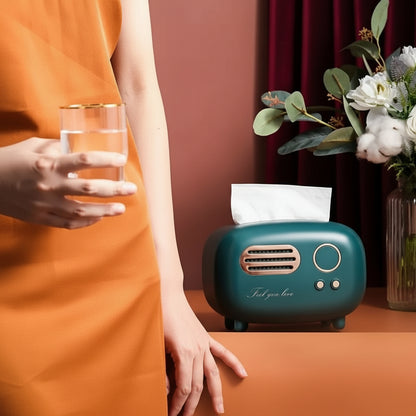 Teal tissue box with floral arrangement and person holding a glass